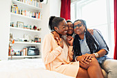 Affectionate multi-generation family hugging on bed