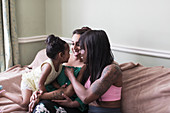 Lesbian couple playing with daughter on sofa