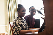 Teenage brother and sister playing piano and singing