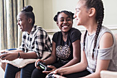 Carefree tween girl friends playing video game