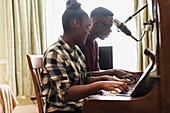 Teenage brother and sister playing piano
