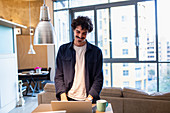 Smiling man using laptop in apartment