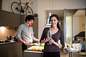 Portrait woman drinking white wine in apartment kitchen