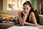Focused woman in pyjamas reading paperwork