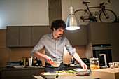 Man cooking dinner in apartment kitchen