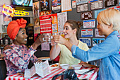 Young friends toasting cocktails in bar