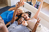 Portrait playful friends laying on bed