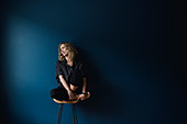 Portrait carefree woman sitting on stool