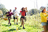 Eager family carrying camping equipment in field