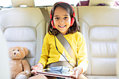 Portrait girl watching movie and tablet in back seat of car