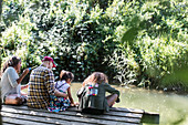 Family relaxing on dock in woods