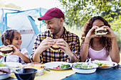 Happy father and daughters eating barbecue hamburgers