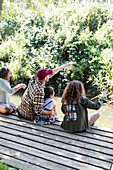 Family blowing bubbles on dock in woods