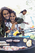 Portrait affectionate sisters enjoying barbecue