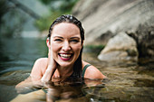Portrait smiling, beautiful woman swimming in lake