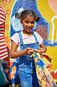 Portrait girl painting vibrant mural on wall