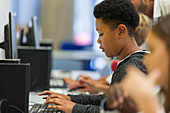 Focused junior high boy student using computer