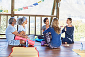 Yoga class talking in circle in hut