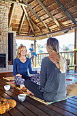 Women talking and drinking tea in hut