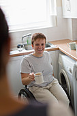 Smiling woman in wheelchair drinking tea