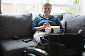 Smiling woman watching TV and eating popcorn