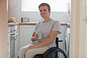 Portrait woman in wheelchair drinking tea
