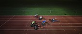Paraplegic athletes racing along sports track in night