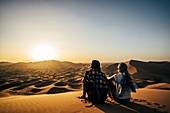 Couple enjoying scenic view of desert, Sahara, Morocco