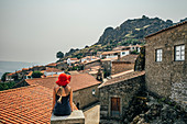 Woman in red hat looking at buildings, Portugal