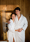 Portrait happy couple in bathrobes at spa