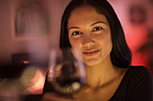 Portrait confident young woman holding wine glass