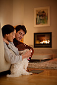 Couple petting dog in living room