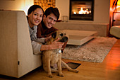 Portrait happy couple with dog in living room