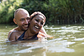 Happy, affectionate couple in river