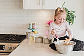 Smiling girl baking on kitchen counter