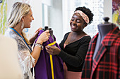 Female fashion designers working at dressmakers model