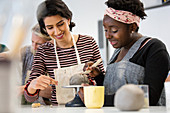 Women molding clay in art class