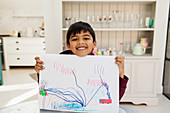 Portrait enthusiastic boy showing drawing