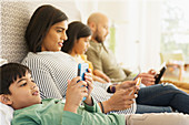 Family using technology on bed