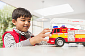 Boy playing with fire engine toy