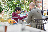 Father and son colouring at table