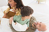 Playful father and children on bed