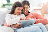 Happy mother and daughter using digital tablet