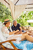 Mature couple using smartphone at resort poolside