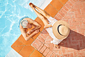 View from above mature couple relaxing at swimming pool