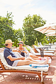 Mature couple relaxing at resort poolside