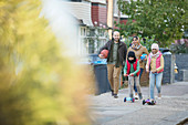Muslim family walking and riding scooters