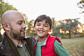 Portrait happy father and son in autumn park
