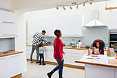 Family doing dishes and making crafts in kitchen