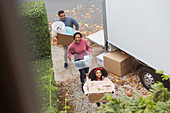 Family moving into new house, carrying boxes